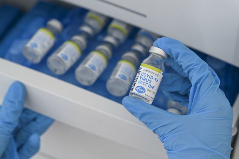 Vials with COVID-19 Vaccine labels showing logos of pharmaceutical company Pfizer and German biotechnology company BioNTech.