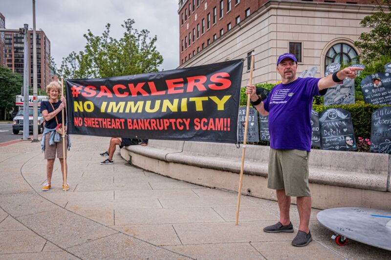 Protesters holding a sign that says, 