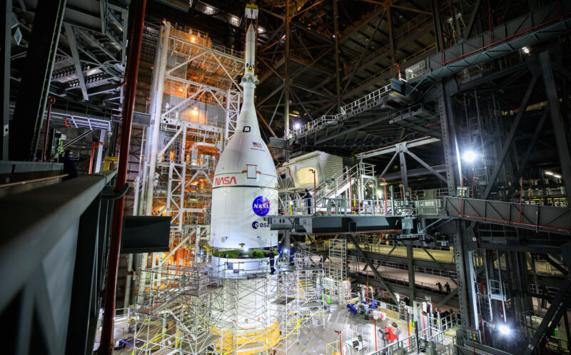 The Orion spacecraft for NASA’s Artemis I mission is lifted above the Space Launch System rocket in the Vehicle Assembly Building at Kennedy Space Center.