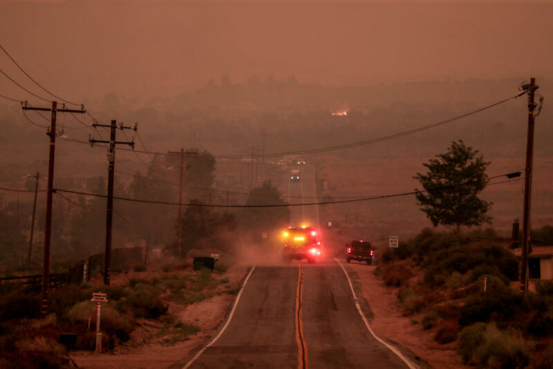 A fire engine drives into air thick with smoke along Juniper Hills Road as the Bobcat Fire advances North into the Antelope Valley in 2020.