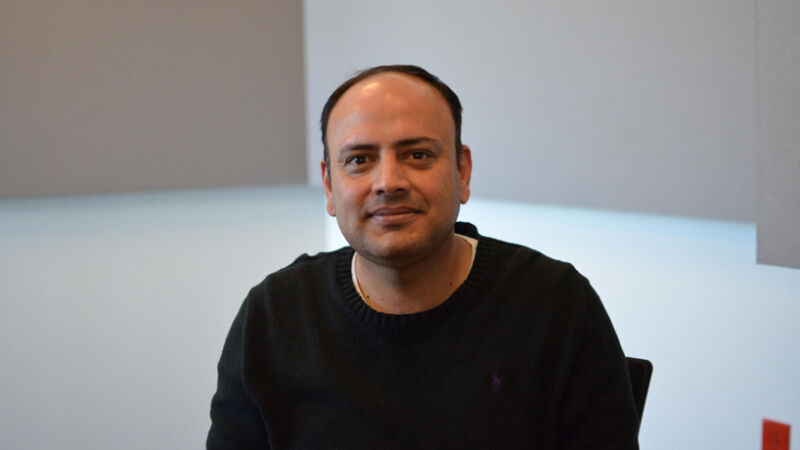 Cybersecurity professor Shaji Khan sitting in a chair.