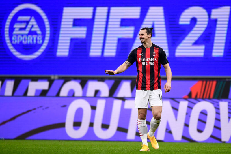 Zlatan Ibrahimovic of AC Milan reacts in front of an EA Sports <em>FIFA 21</em> video game billboard advertising during the Series A football match between AC Milan and Torino FC in 2021. “><figcaption class=