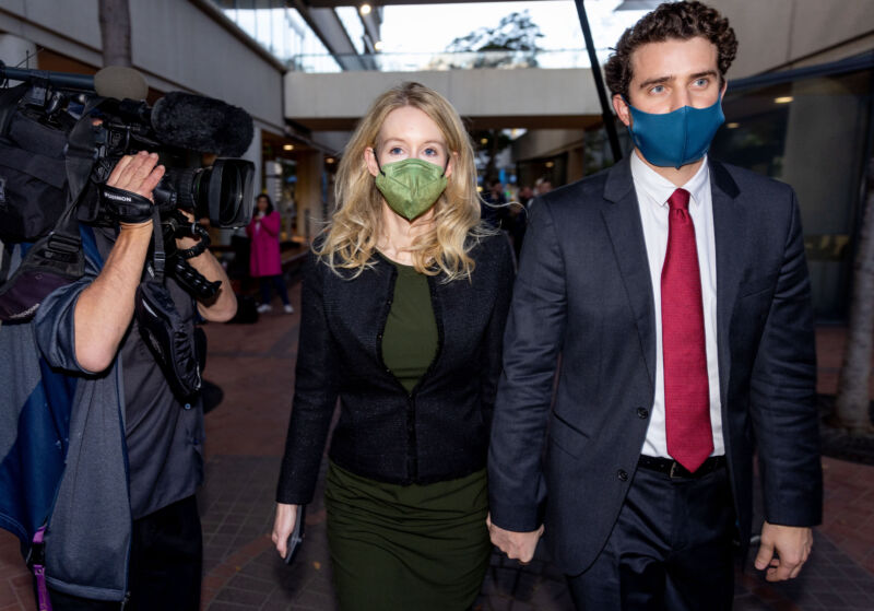 Theranos founder and former CEO Elizabeth Holmes along with her partner, Billy Evans, right, leave the Robert F. Peckham Federal Building on November 23, 2021 in San Jose, Calif.