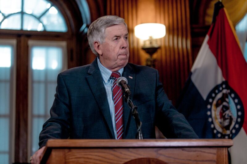 Gov. Mike Parson standing in front of a podium at a press conference.