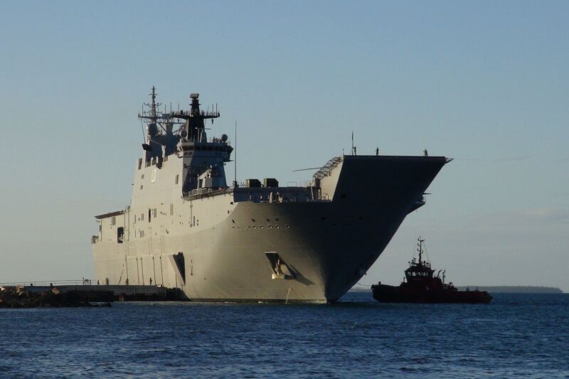 This photo shows the Australian Navy's HMAS <em>Adelaide</em> docked at Vuna Wharf in the Tongan capital of Nukualofa on January 26, 2022. The <em>Adelaide</em> delivered aid following the January 15 eruption of the nearby Hunga Tonga-Hunga Ha’apai underwater volcano. “><figcaption class=