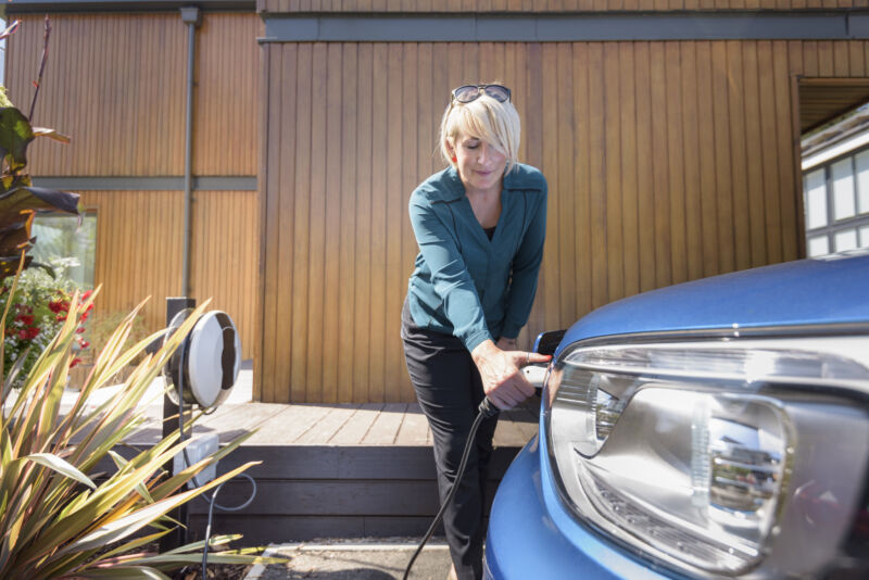 A woman charges an electric car