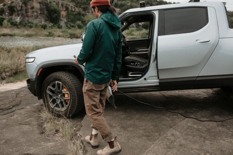 A person carries an air hose to a truck tire