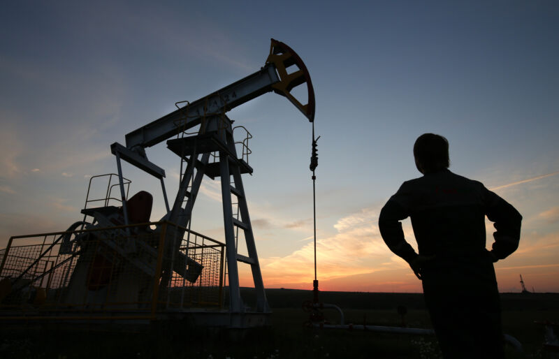 The sun sets beyond an oil pumping unit, also known as a pumping jack, at a drilling site operated by Tatneft OAO near Almetyevsk, Russia.