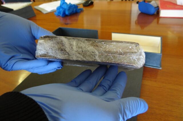 Jim Bloxham, head of Conservation and Collection Care at the Cambridge University Library, examines the still-wrapped notebooks at the start of the unwrapping and verification process.