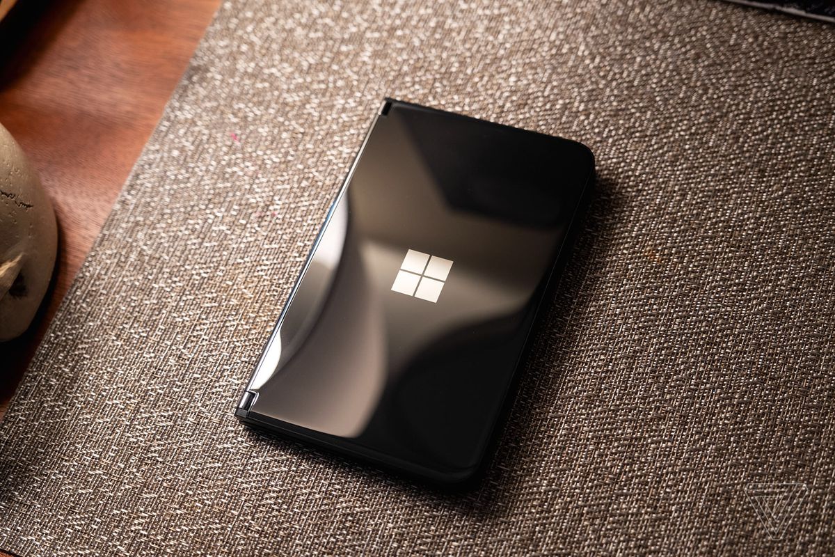 A black Microsoft Surface Duo 2 closed and sitting on a placemat.