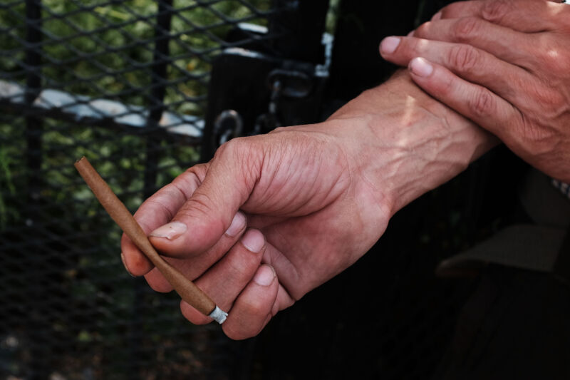 man holds a K2 cigarette