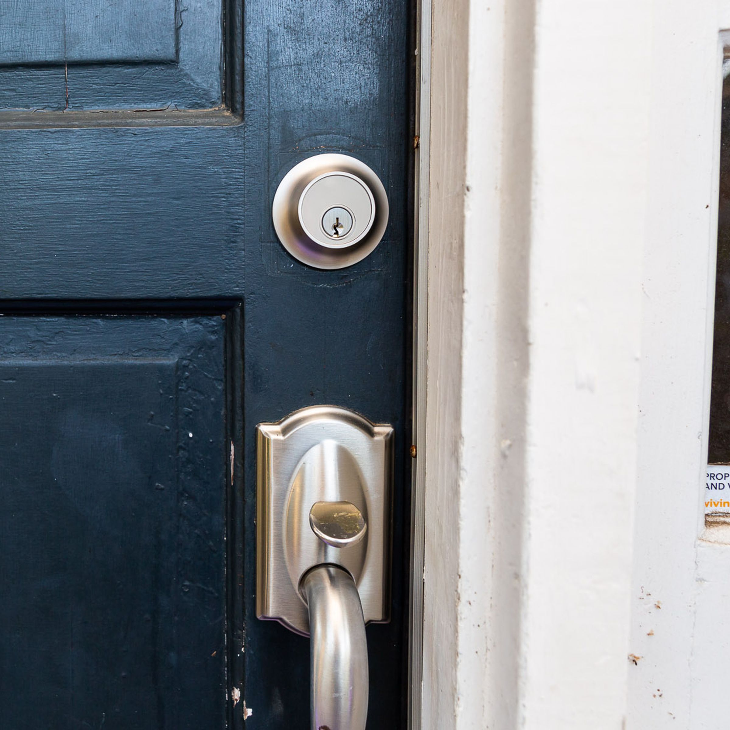 Exterior shot of a front door, with the satin nickel Level Lock Plus installed above a satin-nickel finished handle set.