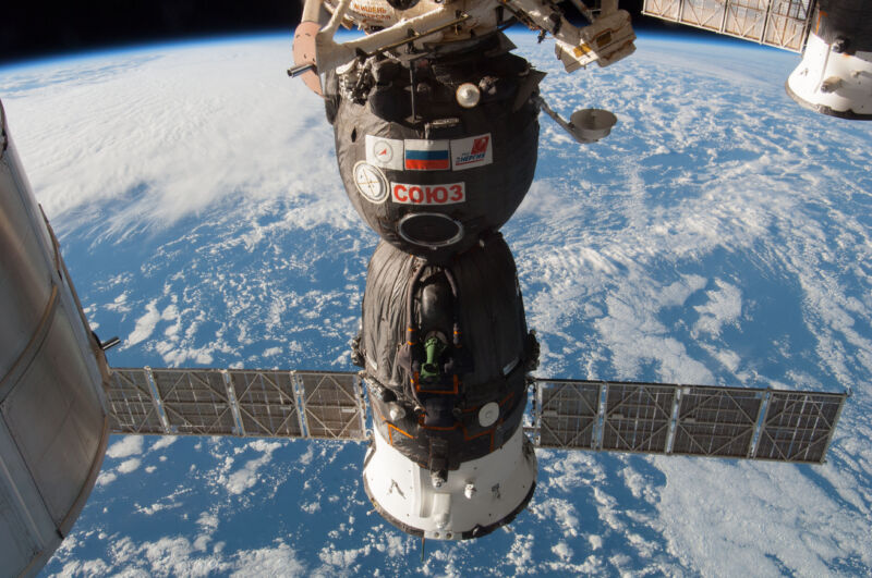 Image of a spacecraft with solar panels and the Earth in the background.