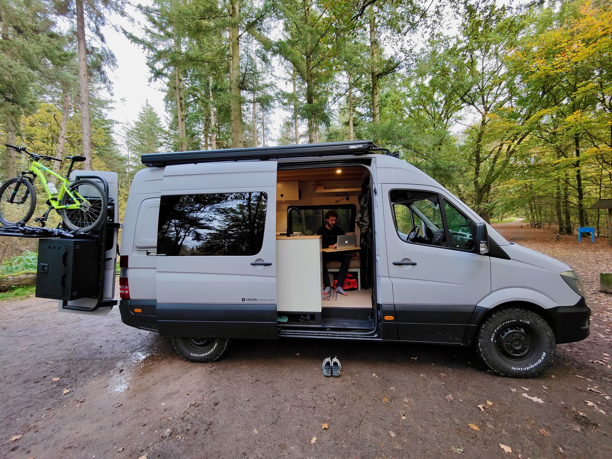 Fabian working inside one of his custom Origin Travelvans Mercedes-Benz Sprinter builds with his brother’s Dutch Van Parts accessories mounted on the roof and rear doors.