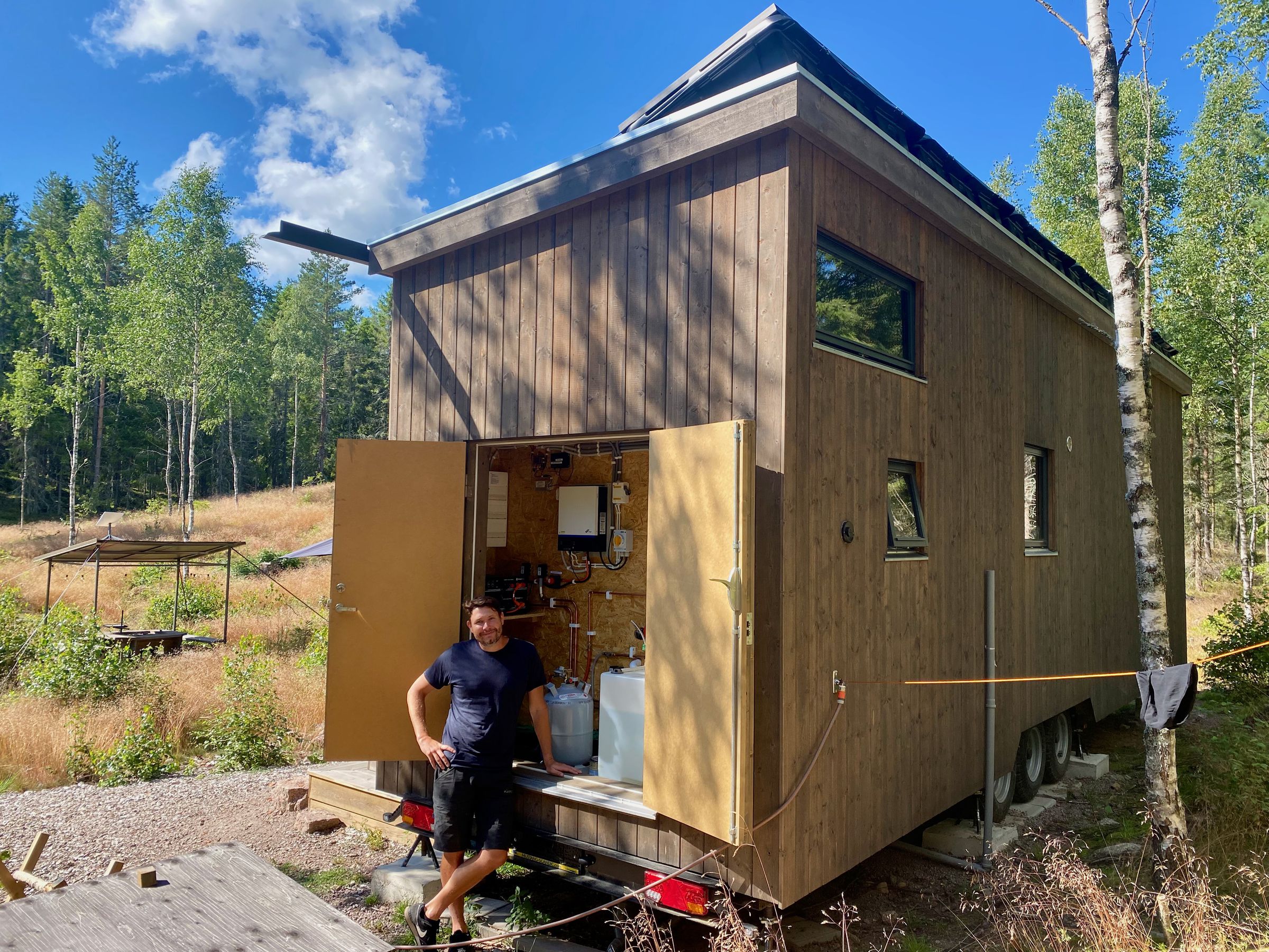 Jesper stands in front of the utility closet where all technology can be found. A water hose connects at the back of the house to replenish the 250-liter tank. We brought our own clothesline. 