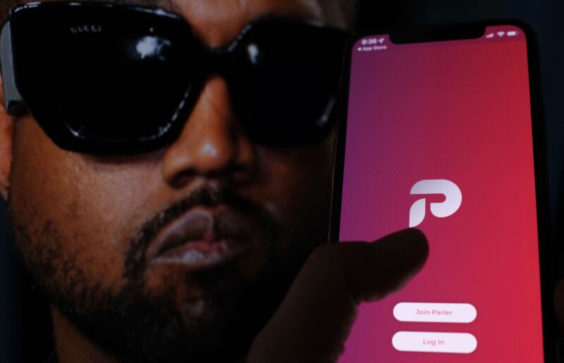 Photo illustration shows the Parler social network app on a smartphone screen with a picture of rapper Kanye West in the background.