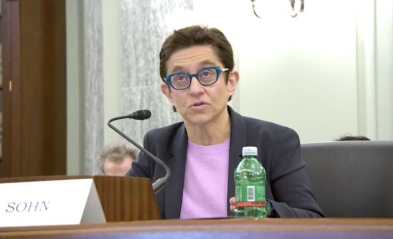 Gigi Sohn sitting and answering questions posted by US senators at a hearing.