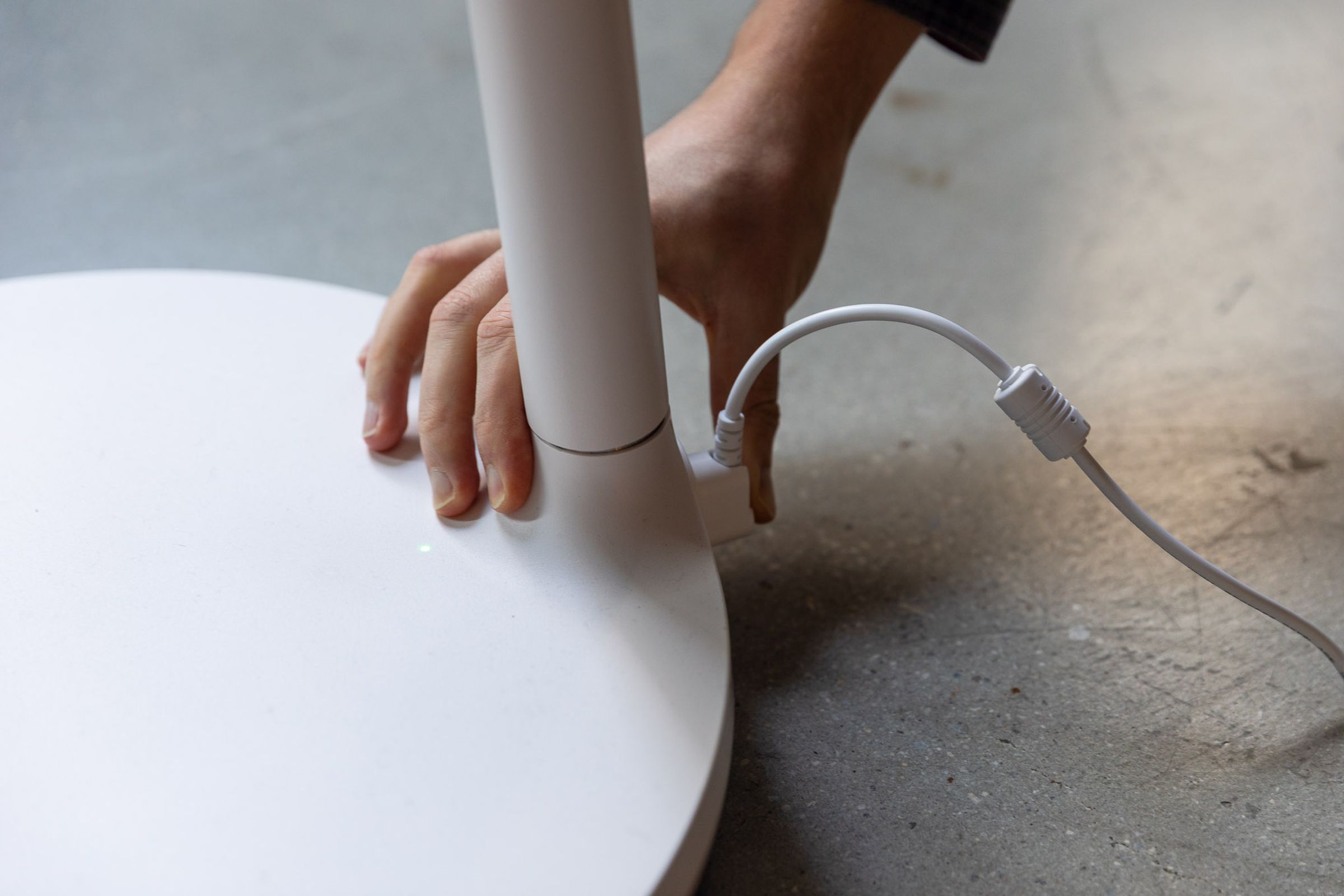 The author is plugging in the power cable to recharge LG’s StanbyME TV.