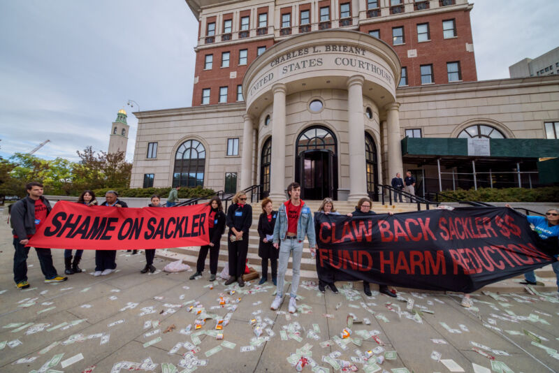 Protesters holding banners outside the courthouse. Members of P.A.I.N. (Prescription Addiction Intervention Now) and Truth Pharm staged a rally and die-in outside New York's Southern District Federal Court in White Plains, where Purdue Pharmaceuticals bankruptcy hearing is being held.