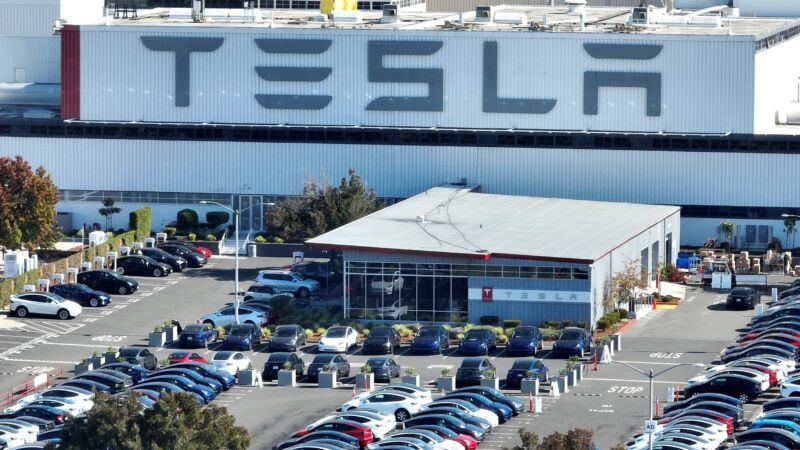 Aerial view of Tesla cars in a parking lot at the Tesla factory in Fremont, California.