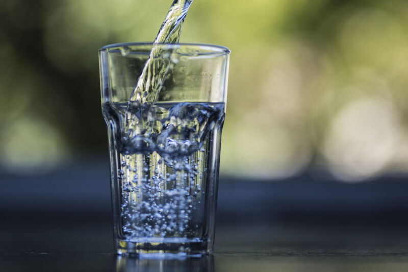 A glass gets filled with drinking water.