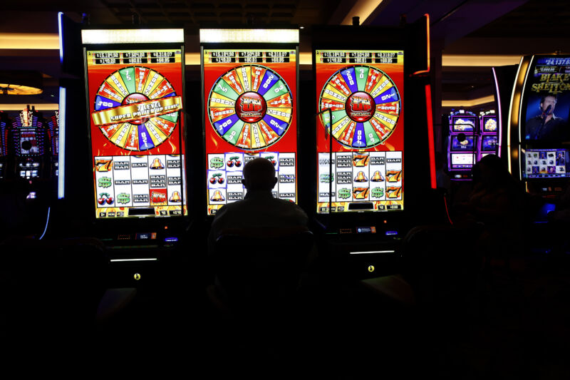 A person sits at the slot machines at a casino.