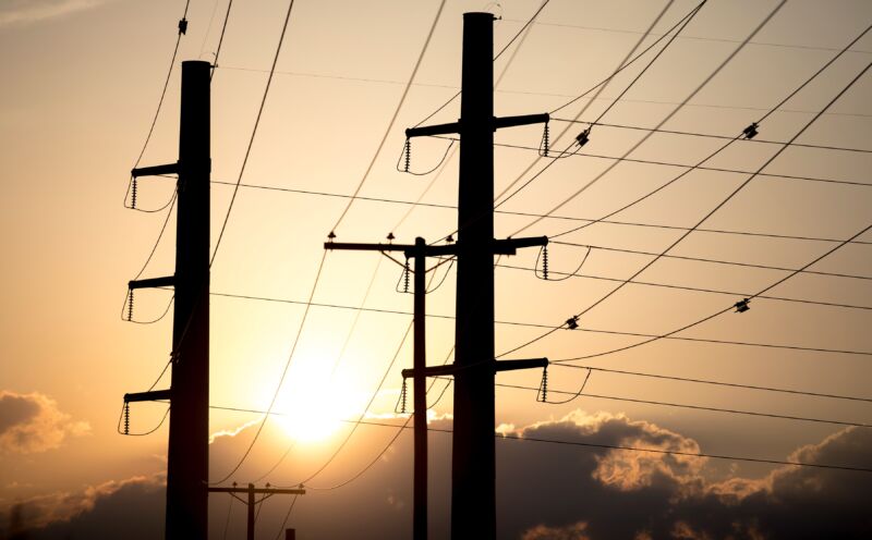 The sun sets behind power transmission lines in Texas