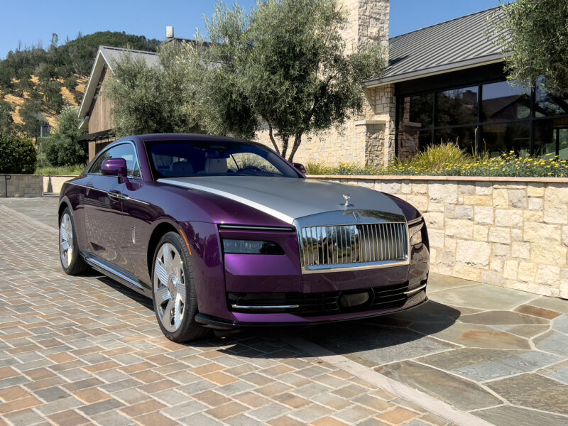 A purple Rolls-Royce coupe with a silver hood