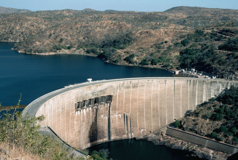 Image of a blue lake behind a concrete dam.