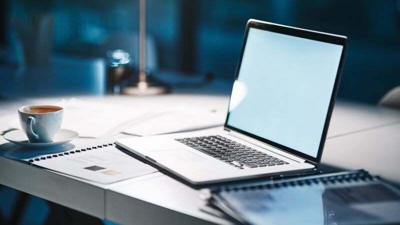 Shot of a laptop on a desk in a modern office at night with no people