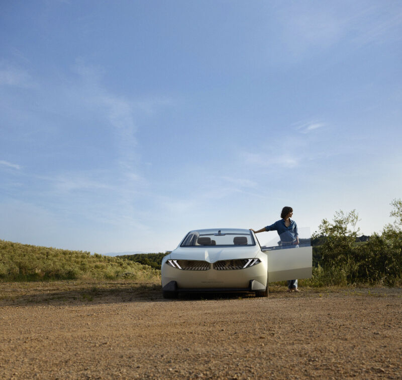 A BMW neue klasse concept in the desert, with a door open