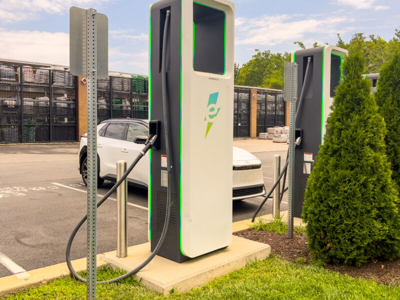 An electrify America charger with a white toyota ev behind it