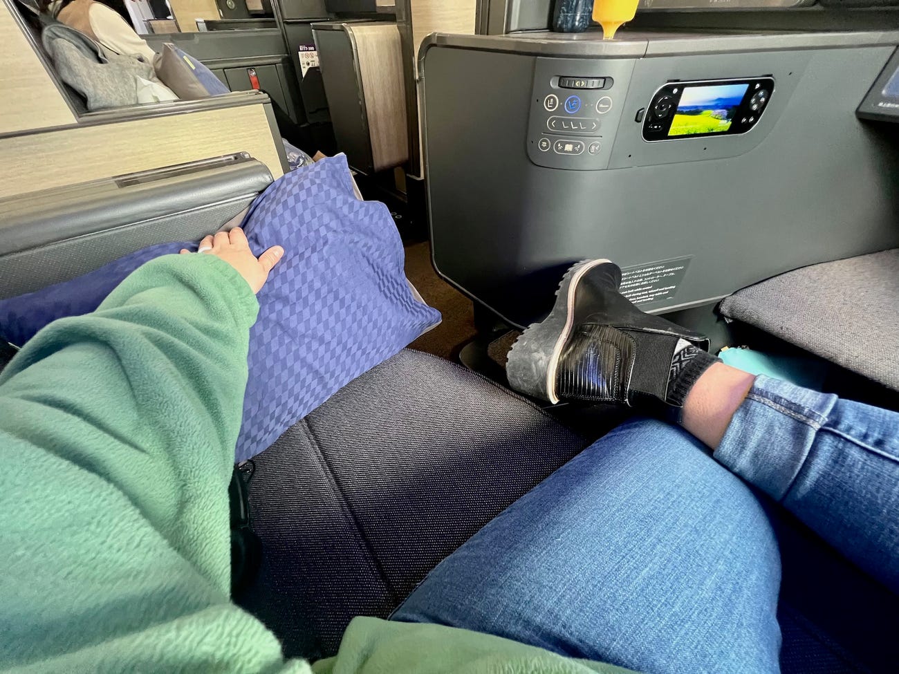 A view of the author's legs crossed on while she sits in a business-class seat.