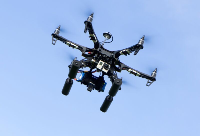 A drone equipped with a camera hovers in the air