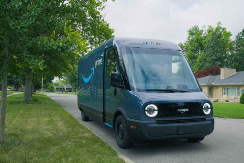 An Amazon electric delivery van parked next to a grassy curb.