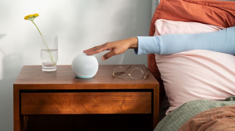 An Amazon Echo Dot on a nightstand.