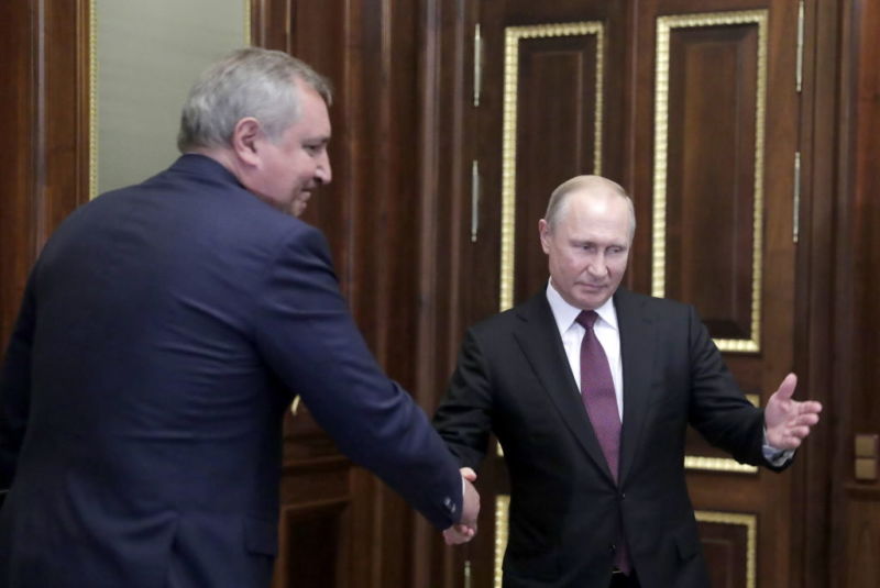 Russia President Vladimir Putin and Roscosmos chief Dmitry Rogozin shake hands during a meeting at the Konstantin Palace.