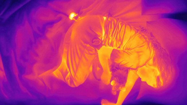 an infrared image of a woman lying in bed