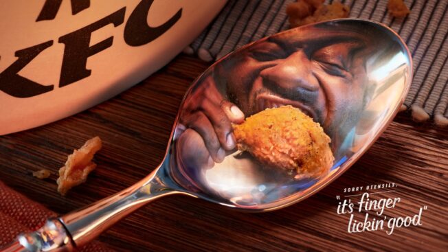 The reflection of a foodie eating fried chicken in a spoon