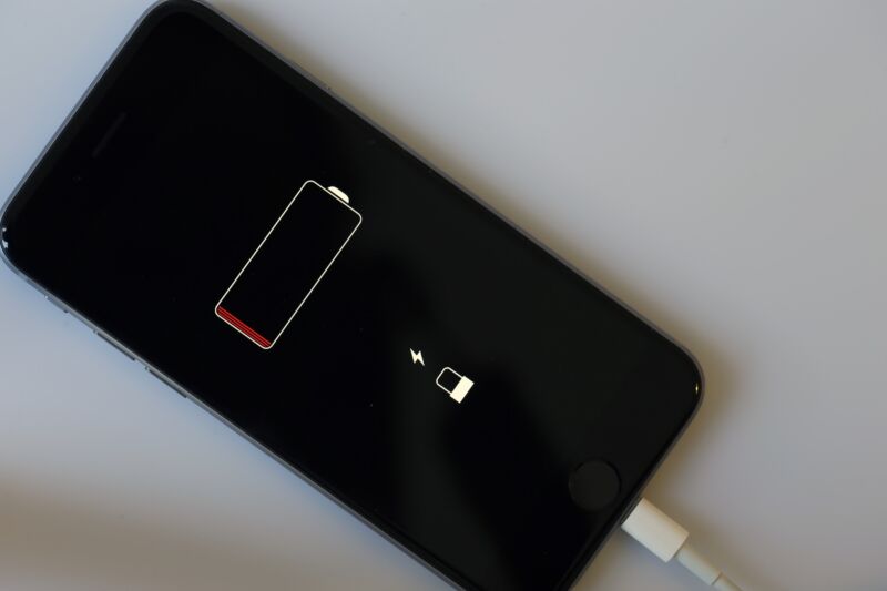 An iPhone that has run out of power displays a black screen with a low-battery icon.