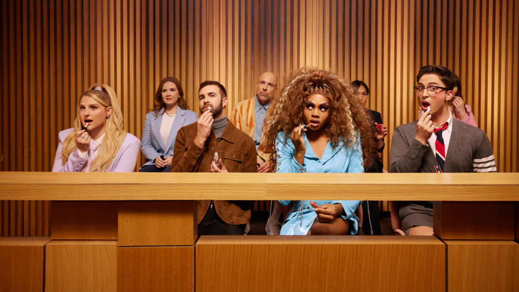 four people sitting in a jury box applying lip products