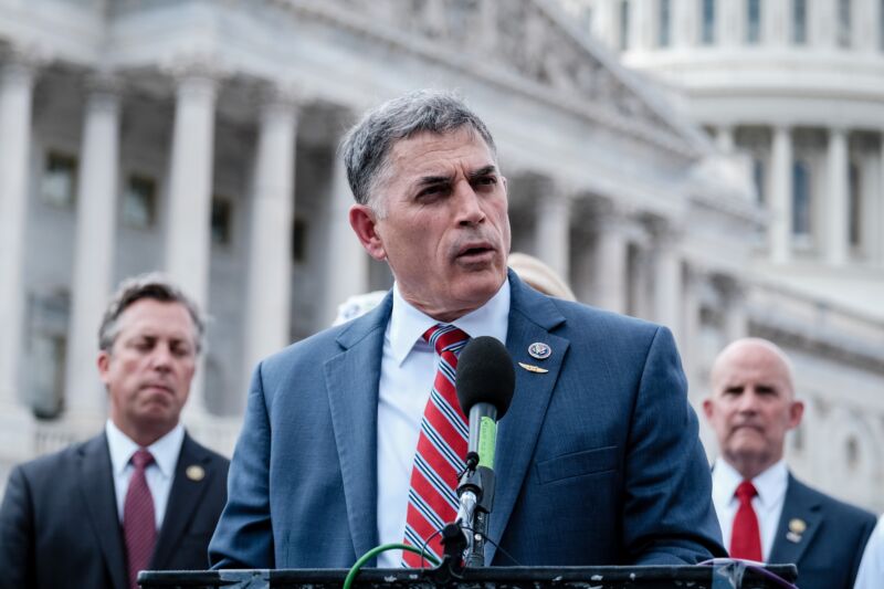 US Rep. Andrew Clyde (R-Ga.) speaks at a podium with a microphone at an outdoor event.