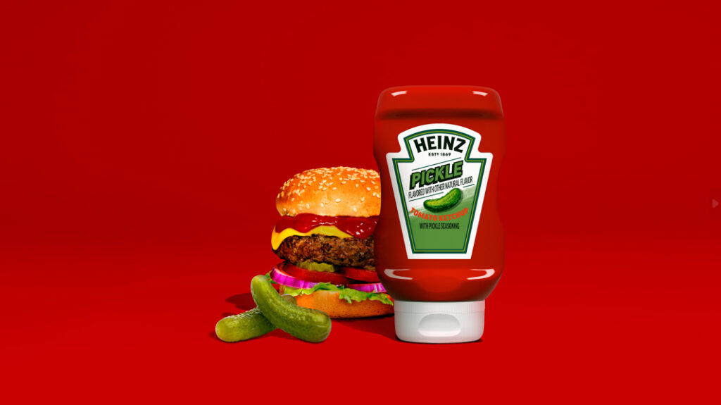 A burger with pickles next to a bottle of Heinz Pickle Ketchup.