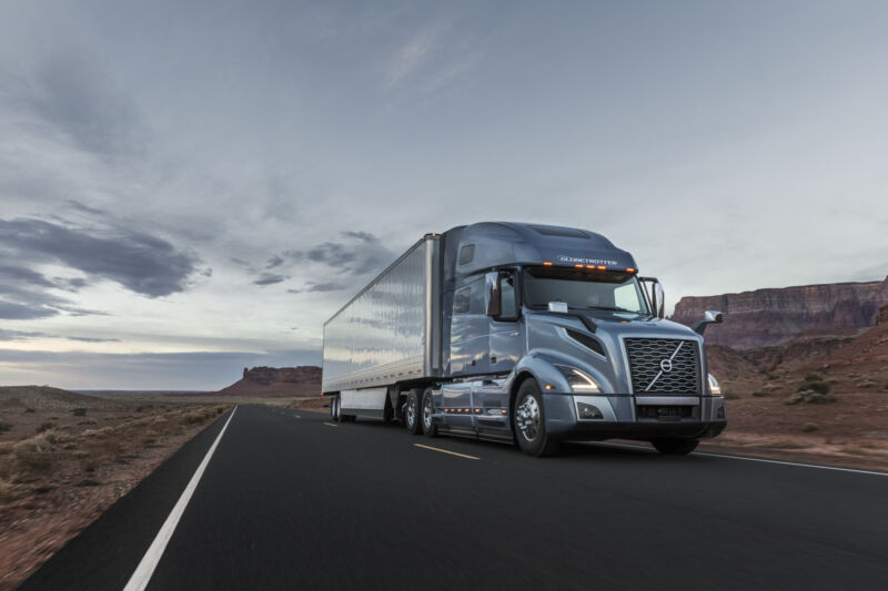 A grey Volvo VNL class 8 truck towing a trailer