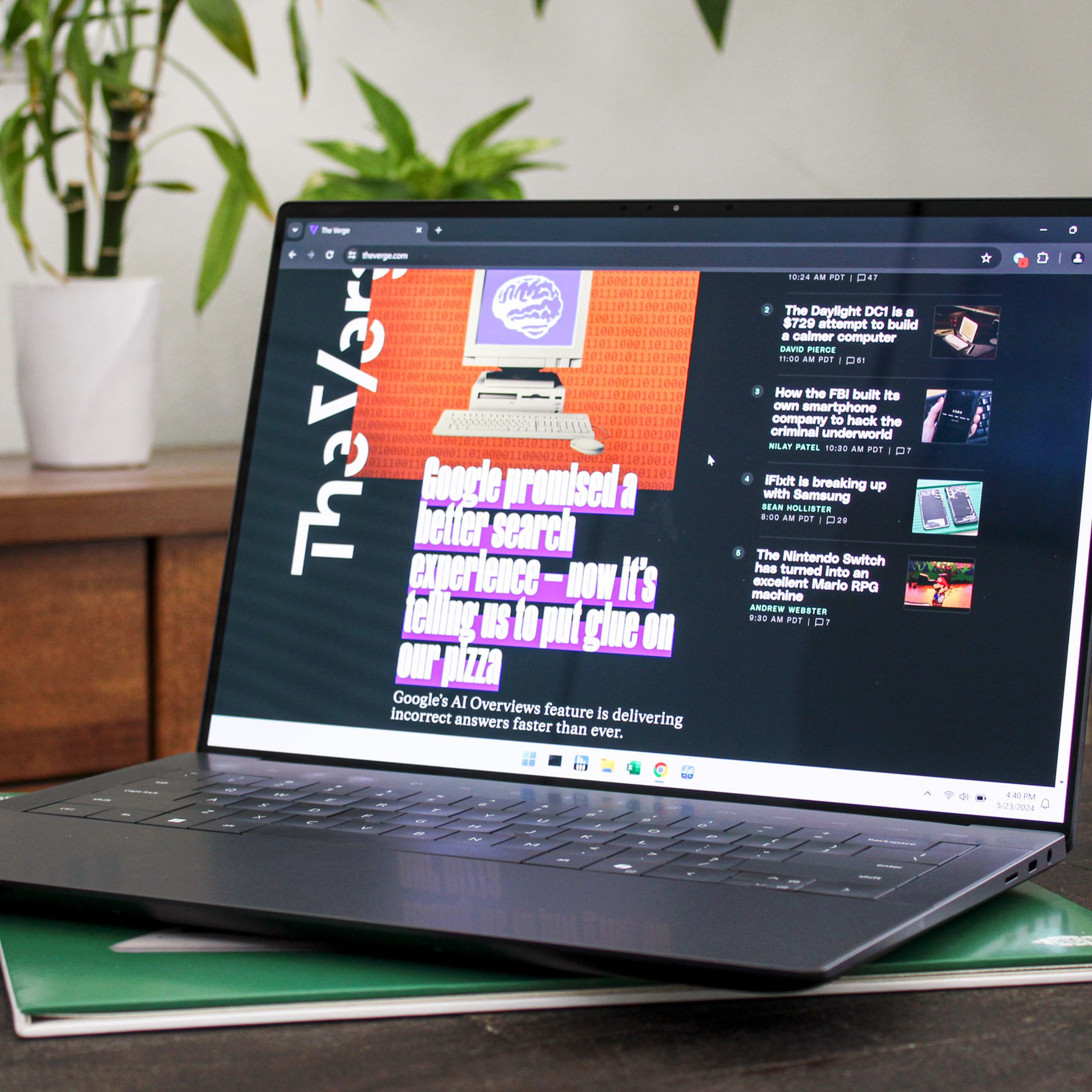 An open and powered on laptop sitting on top of a wood table with plants and furniture in the background.