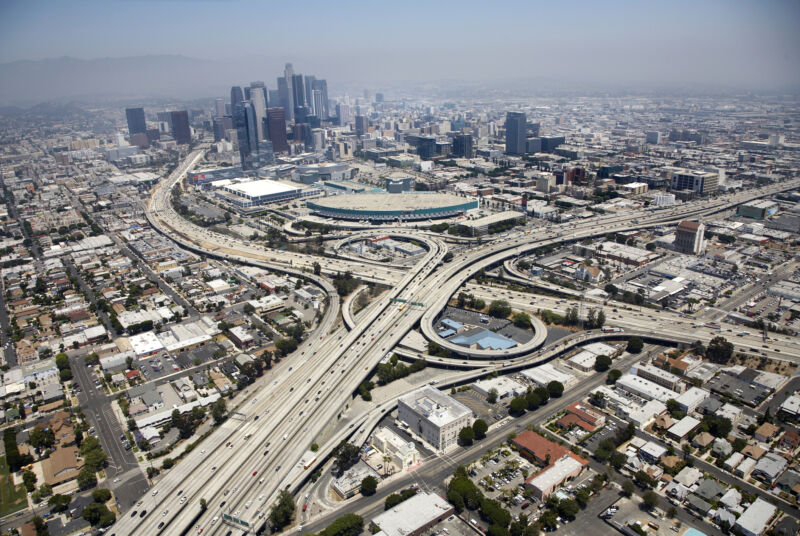 Aerial view of Los Angeles, showing a layer of smog against the hills in the background.