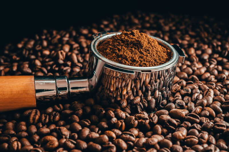 Close-up of coffee beans with roasted beans on table