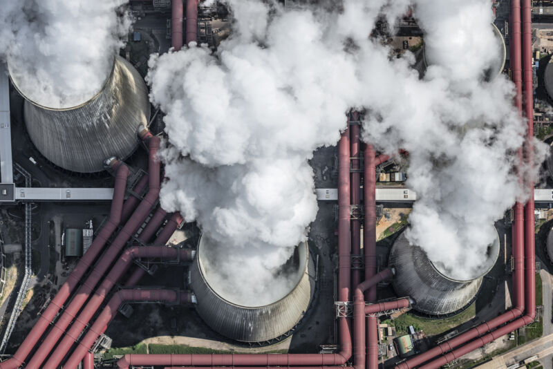 Cooling towers emitting steam, viewed from above.