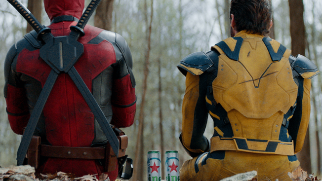 Deadpool and Wolverine sit in the forest with two cans of Heineken Silver