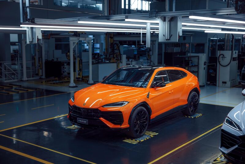 An orange lamborghini Urus at the factory